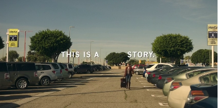 A woman wheeling a suitcase through a rental car parking lot. Text reads: