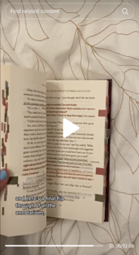 A screenshot of a TikTok video where a hand with blue nail polish holds open a heavily annotated book with pen and highlighter markings. The book's margins are covered with tabs. The book rests on a comforter. The typed phrase
